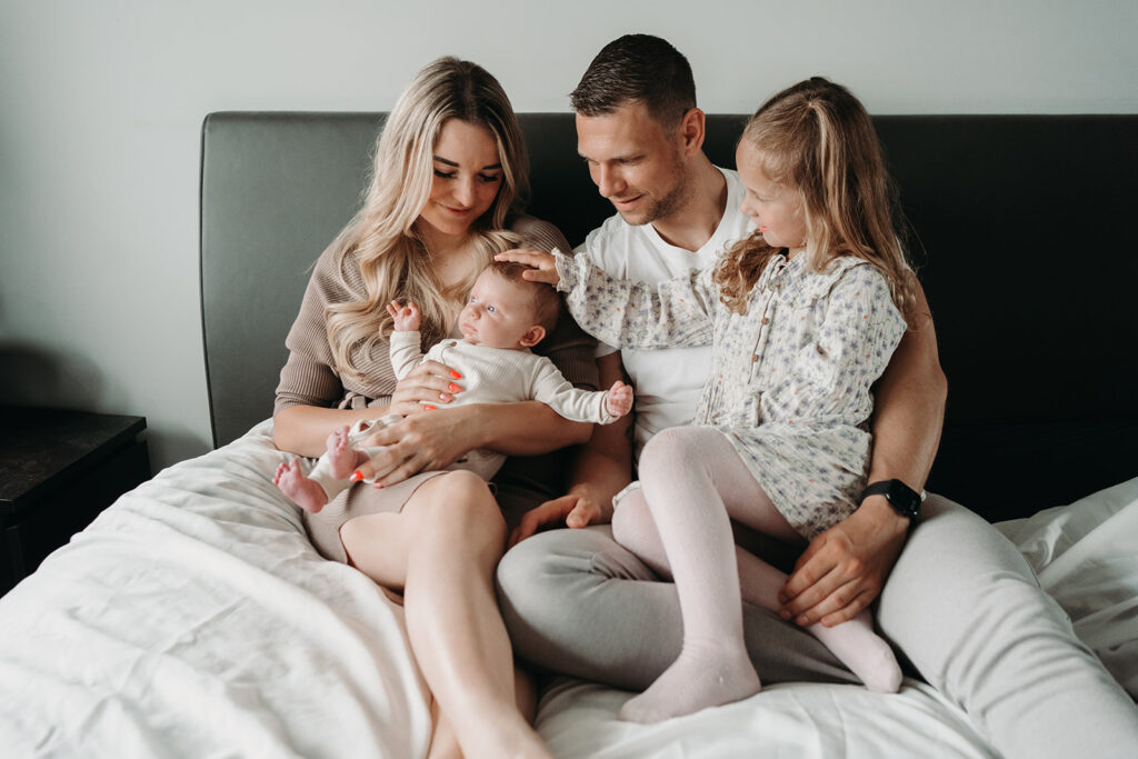 Newbornshoot met het hele gezin, papa, mama en zusje in Meteren. Heel schattig met zijn allen op bed.