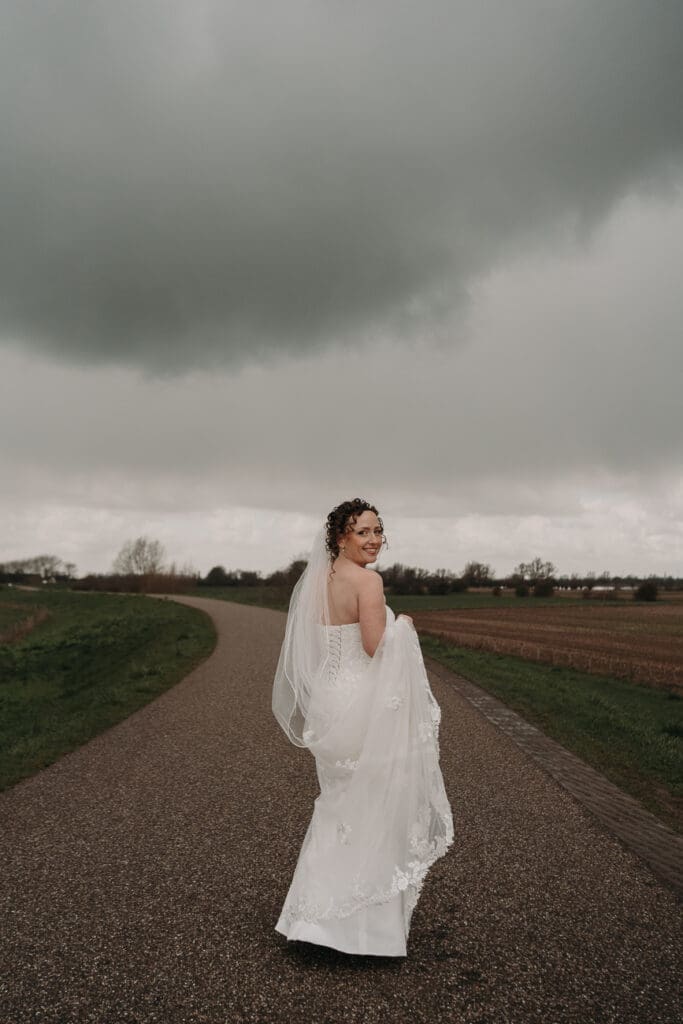 Bruid alleen op de dijk tijdens fotoshoot