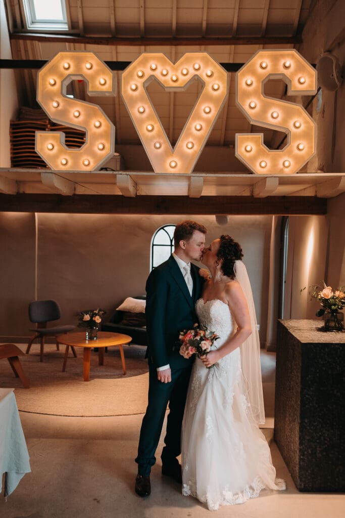 De bruid en bruidegom voor de prachtige lichtletters op hun bruiloft bij VRIJ culemborg