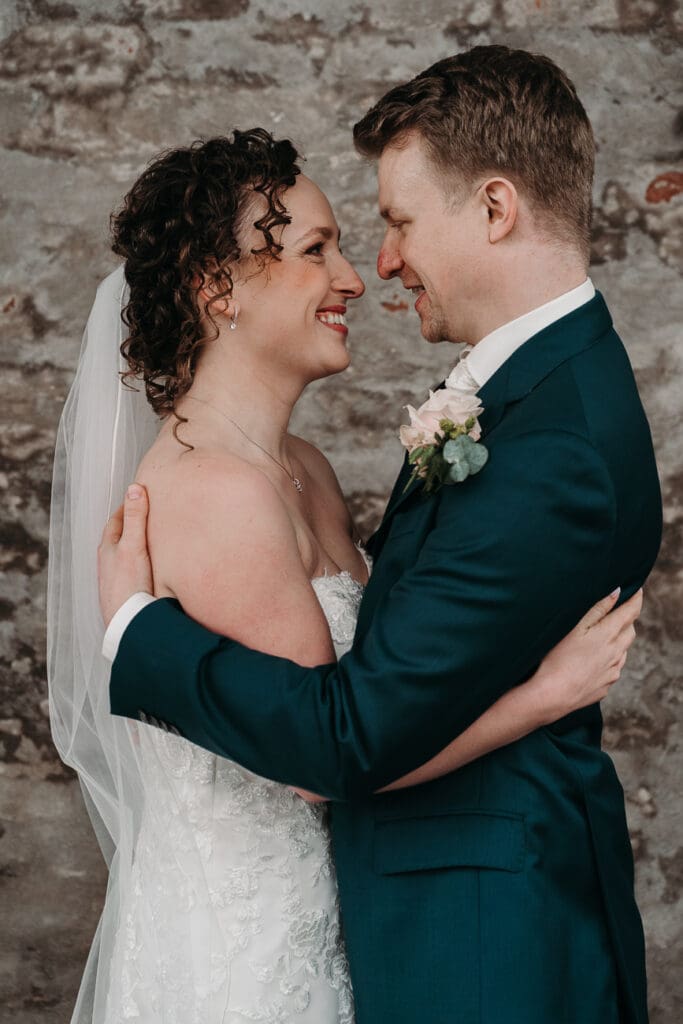 bruid en bruidegom knuffelen elkaar na het lezen van de geloftes